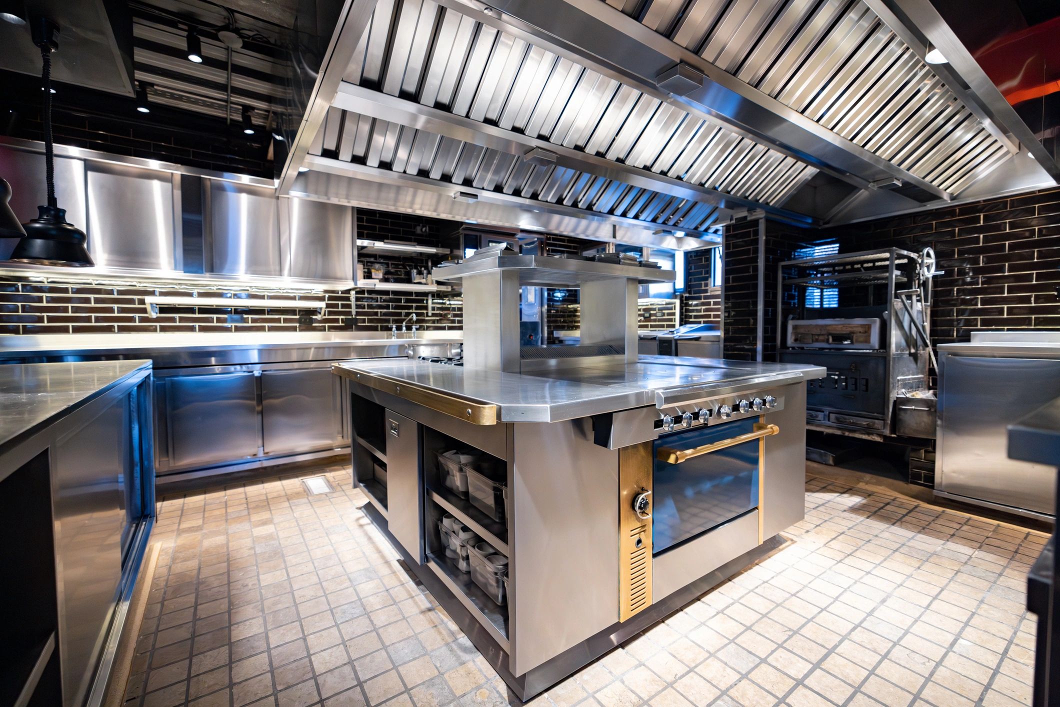 Clean commercial restaurant kitchen with hood system
